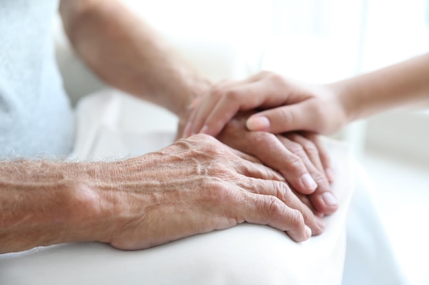 Young woman touching senior man hands closeup