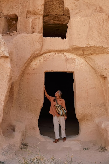 Foto giovane donna che visita la grotta nel parco nazionale del museo all'aperto della cappadocia in turchia