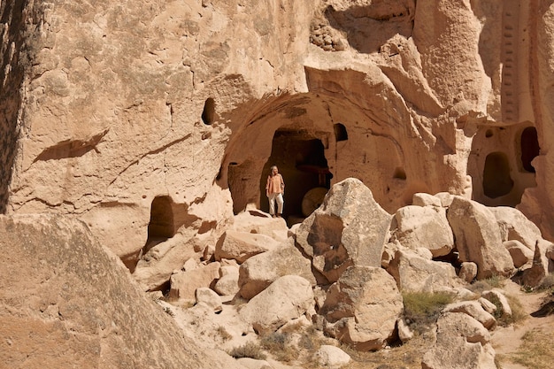 写真 トルコのカッパドキア野外博物館国立公園の洞窟をツアーする若い女性