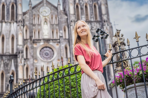 Photo young woman tourist on background of st josephs cathedral in hanoi vietnam reopens after coronavirus