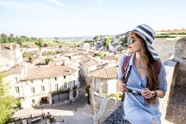 フランスのボルドー地方のサンテミリオン村の美しい街並みの景色を楽しむ若い女性観光客