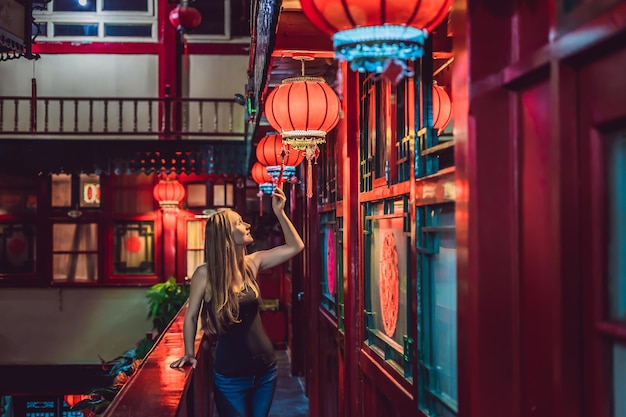 Young woman tourist looks at the chinese traditional lanterns chinese new year travel to china