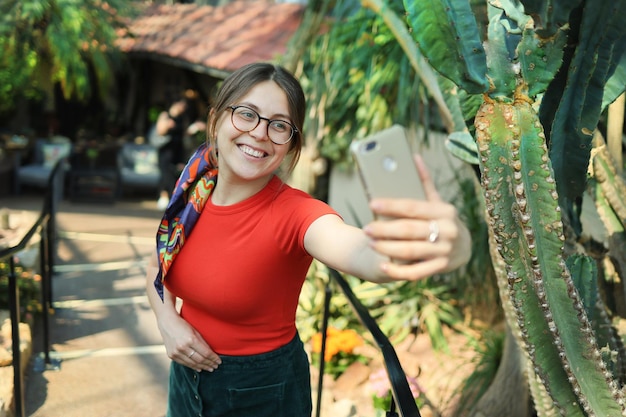 若い女性観光客が植物園で自分撮りをする