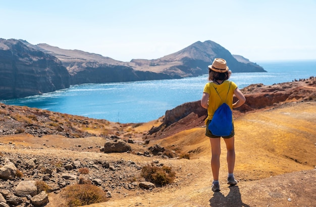 A young woman tourist on the Ponta de Sao Lourenco trail in Baia D'Abra by the beach Madeira coast