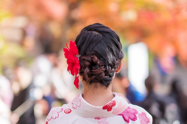 일본 교토 기요미즈데라 사원에서 기모노를 입고 화려한 단풍을 즐기는 젊은 여성 관광객. 가을 단풍 시즌에 일본 전통 옷을 입은 머리 스타일을 한 아시아 소녀