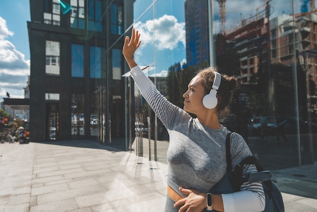 Photo young woman in tracksuit covers with hand from the sun