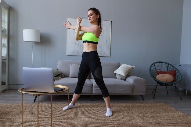 Young woman train at home online with a trainer