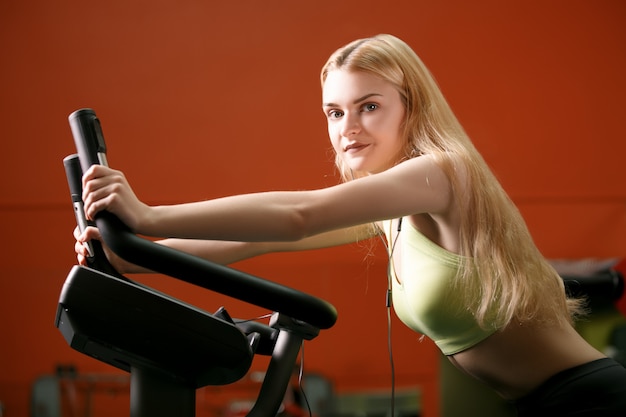 Foto addestramento della giovane donna sulla bici in ginnastica