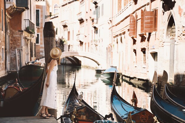 若い女性は、ヴェネツィアの街を歩いているヴェネツィアの観光客のイタリアヨーロッパ美しい景色を旅行します