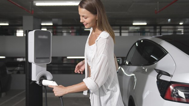 Young woman travel with ev electric car to shopping center parking lot innards