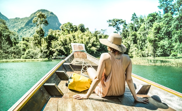 Young woman traveler on longtail boat trip at island hopping in Cheow Lan Lake