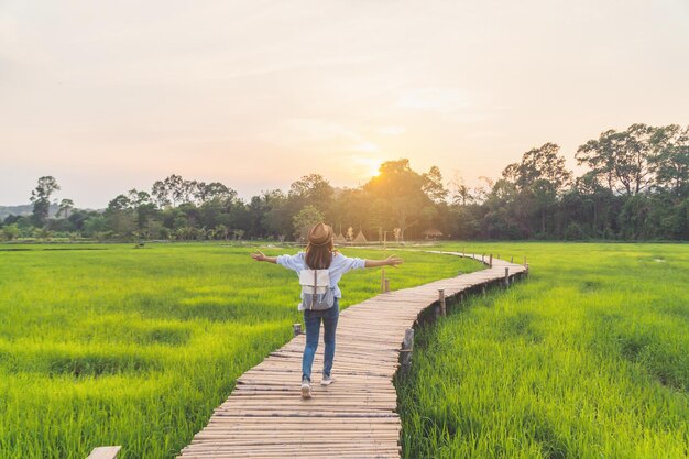 Photo young woman traveler looking at beautiful green paddy field