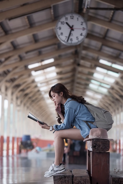 Young woman traveler  sitting on wooden bench 