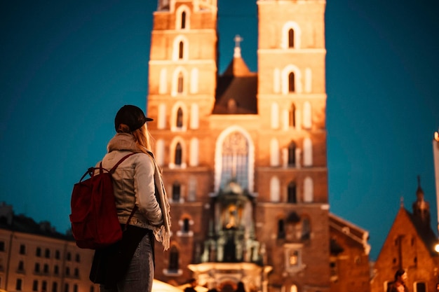 Young woman traveler in St Mary's basilica in main square of Krakow Wawel castle Historic center city with ancient architecture