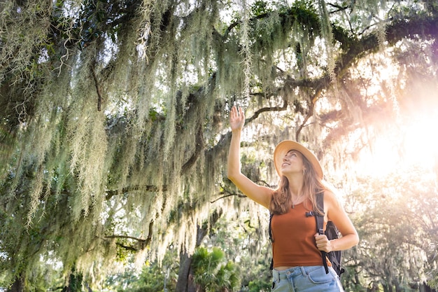 Young woman traveler with backpack feeling free and happy. Brave and empowered solo traveler woman.