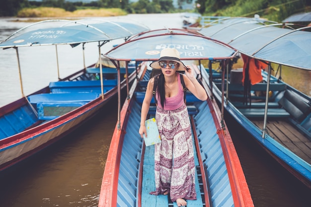 A young woman traveling by boat at a pier