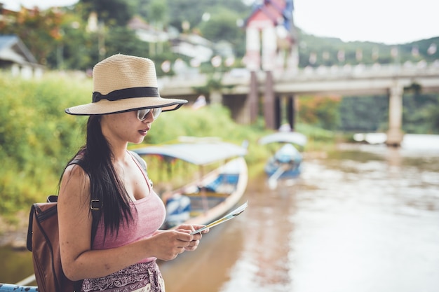 桟橋でボートで旅行する若い女性