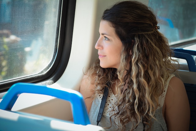 電車で旅行する若い女性