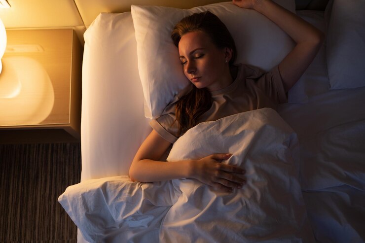 若い女性は夜にベッドで転がって寝ようとします 眠れない女性はホテルに横たわっています