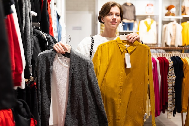 Young woman trying on clothes looking in the mirror in the mall