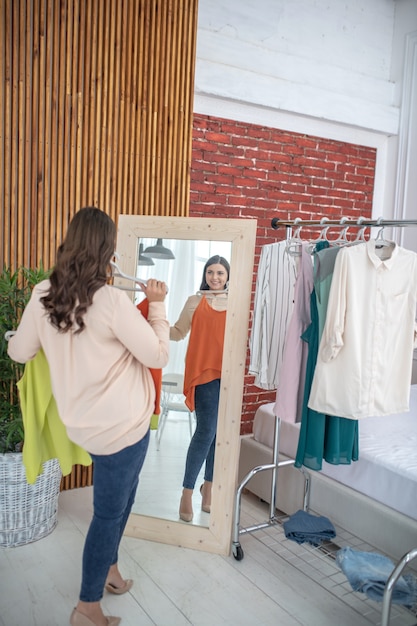 Young woman trying a new orange shirt