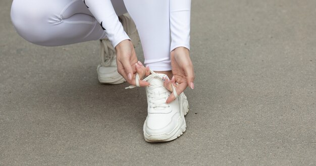 若い女性が彼女の靴ひもを結ぶ