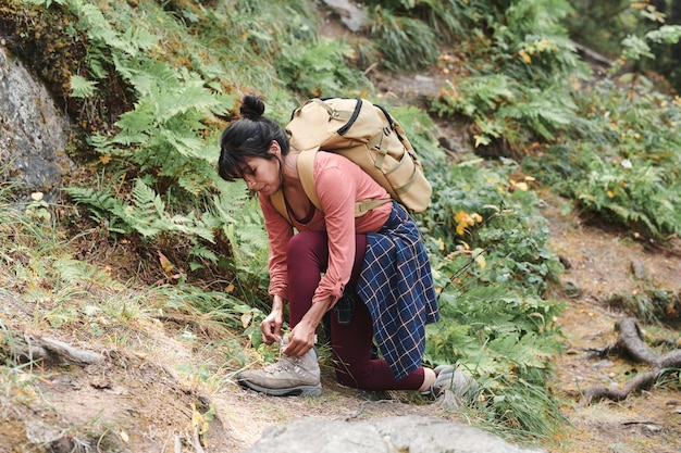 Young woman tying shoelace