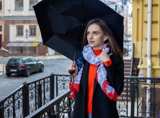 Photo young woman under an umbrella on a city street