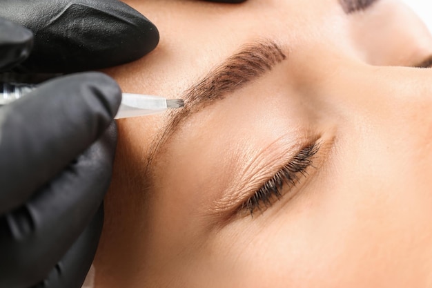 Young Woman Undergoing Eyebrow Correction Procedure in Salon