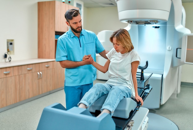 Young woman undergoing radiation therapy for cancer under the\
supervision of doctors