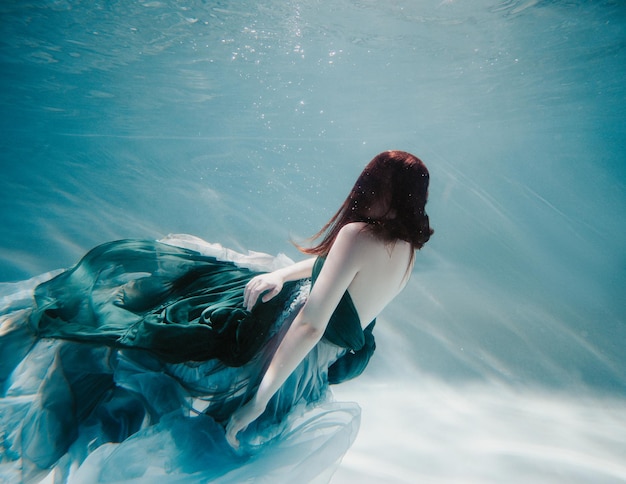 Young woman underwater in a beautiful dress underwater shooting