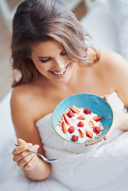 young woman in underwear eating cereals