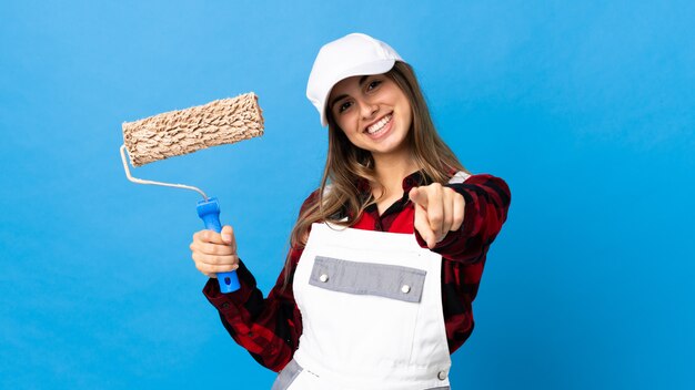 Giovane donna in uniforme con rullo di pittura