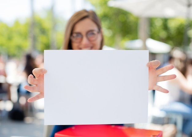 Foto giovane donna all'università che mostra un cartello