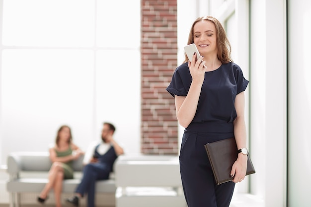 young woman uses her smartphone in the office .