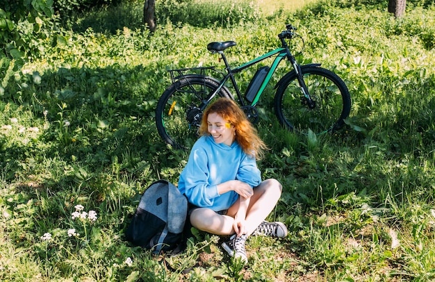 한 젊은 여성이 스포츠와 야외 레크리에이션을 위해 현대적인 전기 자전거를 사용합니다.
