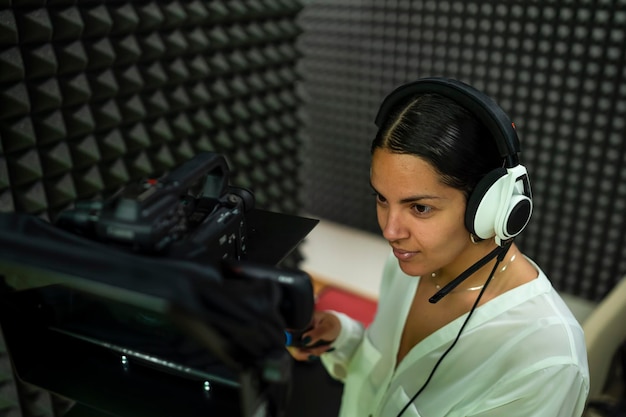 Young woman using a broadcast camera on set