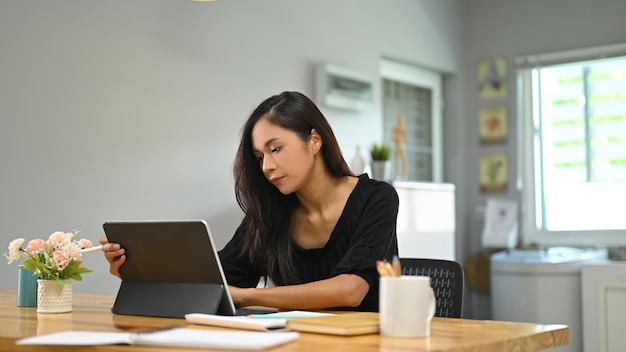 座ってコンピュータタブレットを使用して若い女性