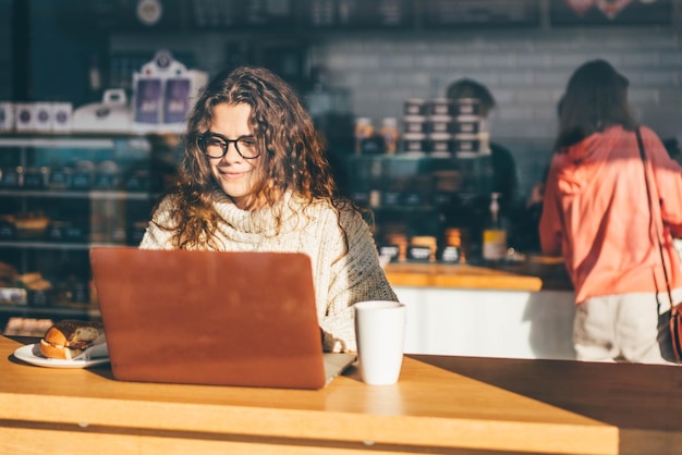 Young woman using digital tablet while sitting on table