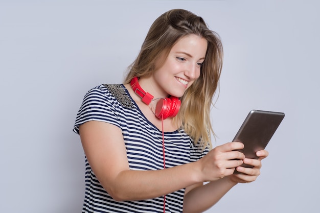 Giovane donna che per mezzo della compressa digitale.