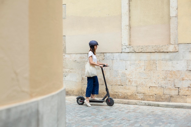Giovane donna che utilizza uno scooter ecologico
