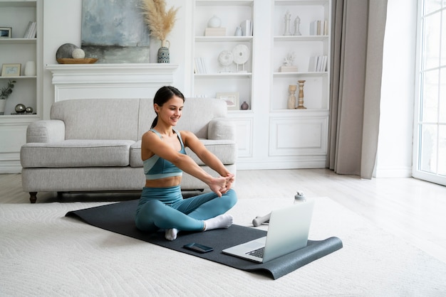 Photo young woman using a fitness mat to workout