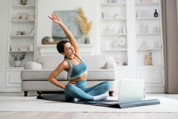 Photo young woman using a fitness mat to workout