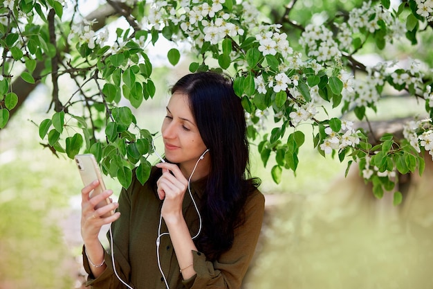 Young woman using headphones listen to music online meeting or\
chatting by phone taking webinar lesson listen online course learn\
language in app relaxing and leisure