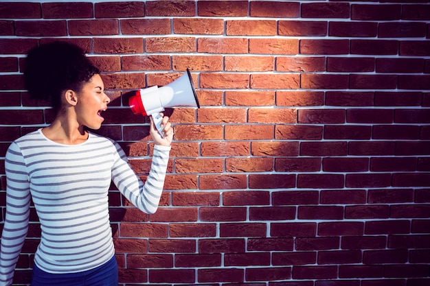 Young woman using her megaphone in the light 