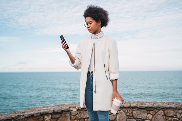 若い女性が彼女の携帯電話を使用しています。