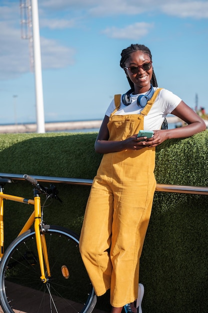 Молодая женщина с помощью смартфона в солнечный день у моря Концепция образа жизни в социальных сетях гуляет по городу