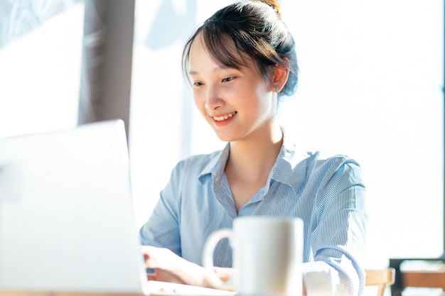 写真 テーブルでラップトップを使用する若い女性