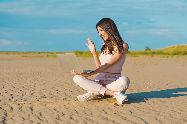 Young woman using the laptop on the beach