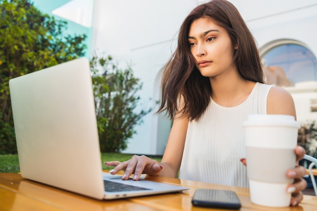 Young woman using laptop at coffee shop.